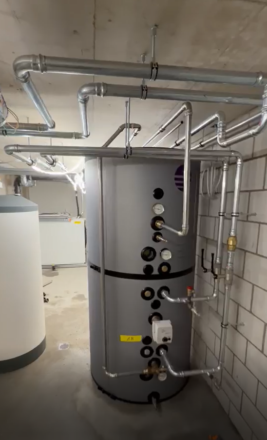 Pufferspeicher mit Anschlussleitungen in einem Heizraum
